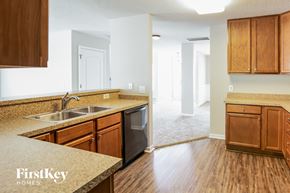 Summerville house for rent - a kitchen with wood flooring and a sink and wooden cabinets