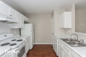 Charlotte house for rent - a kitchen with white cabinets and white appliances and a sink