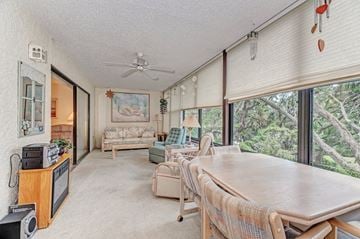 Bradenton house for rent - a dining room with a table and a living room with large windows