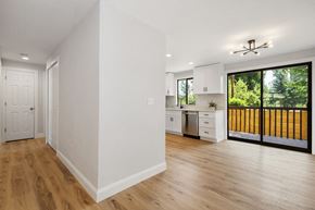 Bothell apartment for rent - an open kitchen and living room with white walls and wood floors