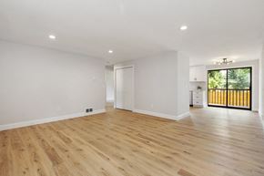 Bothell apartment for rent - a living room with white walls and wooden floors and a door to a balcony