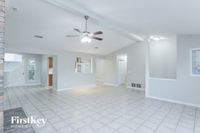 Orange Park house for rent - A spacious, empty room with a fan and tiled flooring.