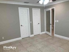 Cape Coral house for rent - a living room with three doors and a tiled floor