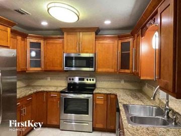 Cape Coral house for rent - a kitchen with wooden cabinets and stainless steel appliances