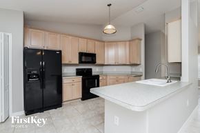 Palm Bay house for rent - a large kitchen with black appliances and white counter tops