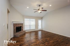 Fort Worth house for rent - a living room with a fireplace and a ceiling fan