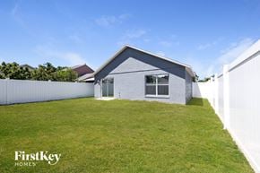 Kissimmee house for rent - a small with a grass yard and a white fence