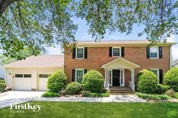 High Point house for rent - a large brick house with a white garage door