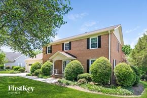 High Point house for rent - a brick house with green shutters and a lawn and trees