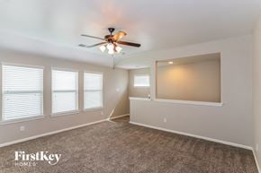 Baytown house for rent - A spacious room with a ceiling fan and carpeted floor.