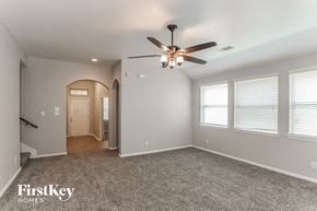 Baytown house for rent - A spacious room with a ceiling fan and carpeted floor.