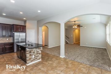 Baytown house for rent - A kitchen with a refrigerator, sink, and cabinets is shown in a home by FirstKey Homes.