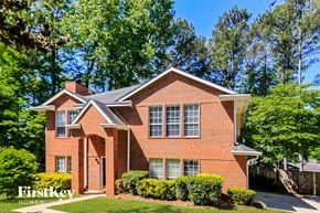 Marietta house for rent - the front of a brick house with a yard and trees
