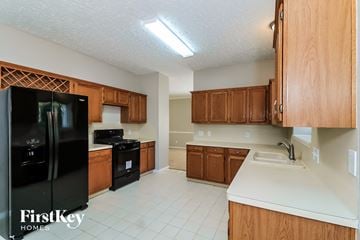 Marietta house for rent - a kitchen with black appliances and wooden cabinets