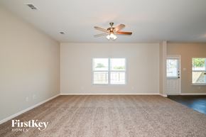 Dallas house for rent - an empty living room with a ceiling fan and a carpet