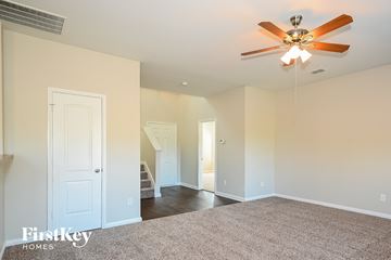 Dallas house for rent - a living room with a ceiling fan and a carpet