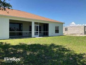 Cape Coral house for rent - A white house with a red roof and a grassy lawn in front.