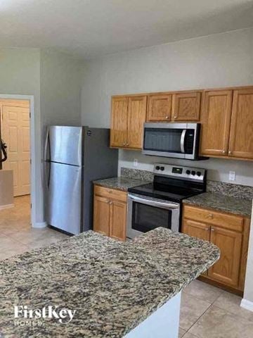 Cape Coral house for rent - A kitchen with granite countertops and wooden cabinets.