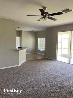 Cape Coral house for rent - A room with a ceiling fan and a carpeted floor.