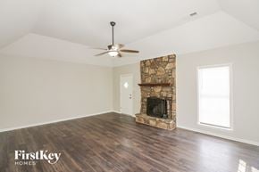 Memphis house for rent - A room with a stone fireplace and a ceiling fan.