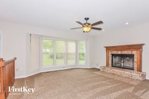 Saint Peters house for rent - a living room with a fireplace and a ceiling fan