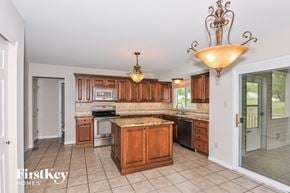 Saint Peters house for rent - a kitchen with wooden cabinets and stainless steel appliances