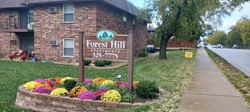 Westmont apartment for rent - the forest hill apartments sign in front of a brick building