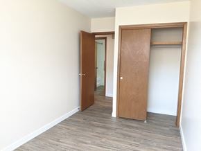 Regina apartment for rent - A room with a wooden floor and two wooden doors.