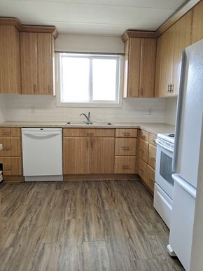 Regina apartment for rent - A kitchen with wooden cabinets and a white fridge.