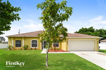 Lehigh Acres house for rent - a yellow house with a tree in the yard