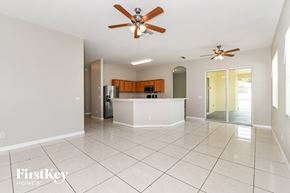 Lehigh Acres house for rent - an open kitchen and living room with tile flooring and a ceiling fan