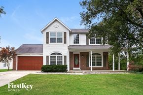 Carmel house for rent - a white house with a green lawn and a red garage door