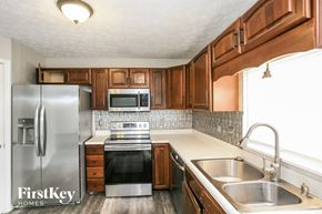Carmel house for rent - a kitchen with wooden cabinets and stainless steel appliances