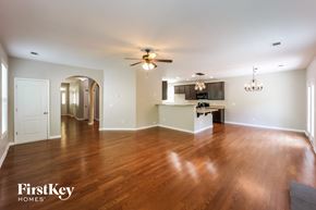 Newnan house for rent - A spacious room with wooden floors and a ceiling fan.