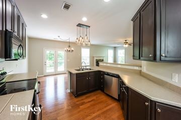 Newnan house for rent - A kitchen with dark wood cabinets and a stainless steel dishwasher.