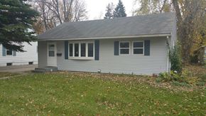 Grand Forks house for rent - a front view of a white house with blue shutters
