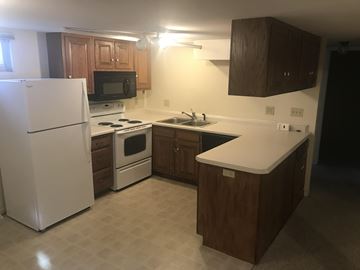 Grand Forks house for rent - A kitchen with a white refrigerator, white stove, and white countertop.
