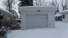 Grand Forks house for rent - A white garage door is closed in front of a house.