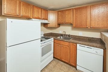 Yarmouth apartment for rent - a kitchen with white appliances and wooden cabinets