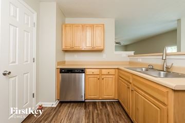 Mcdonough house for rent - a kitchen with wooden cabinets and a stainless steel dishwasher