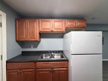 East Point apartment for rent - A kitchen with brown cabinets and a white refrigerator.