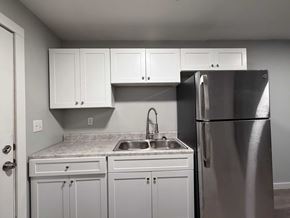 East Point apartment for rent - A kitchen with white cabinets and a stainless steel refrigerator.