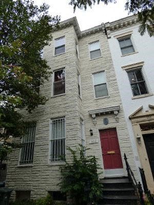 Washington apartment for rent - A white building with a red door and a black staircase.