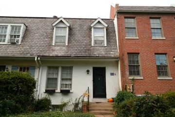 Washington apartment for rent - A white house with a black door and a brick house to the right.