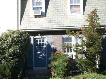 Washington apartment for rent - A house with a blue door surrounded by greenery.