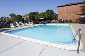Glendale Heights apartment for rent - a swimming pool with chairs and a building in the background