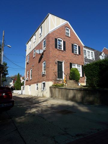Washington apartment for rent - A red brick building with a white trim and black shutters.