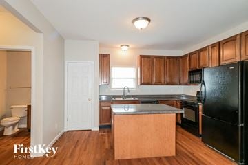 O'fallon house for rent - A kitchen with wooden cabinets and black appliances.