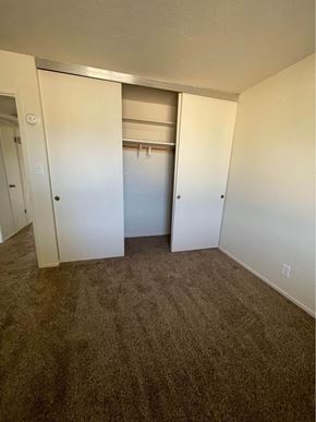 Hayward apartment for rent - A room with a carpeted floor and a closet with a door open.