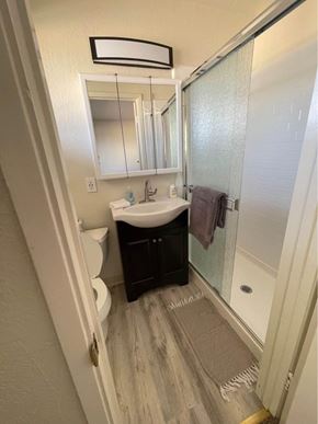 Hayward apartment for rent - A bathroom with a sink, mirror, toilet, and shower.